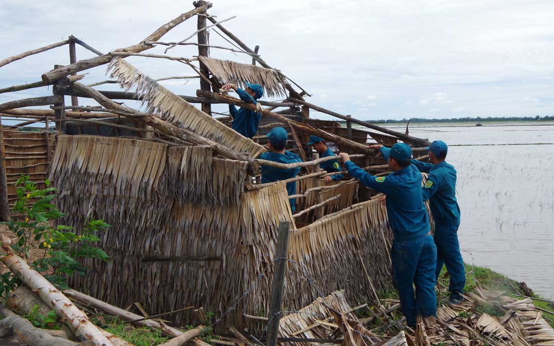 Lực lượng dân quân giúp dân sửa lại nhà bị giông bão làm hư hỏng