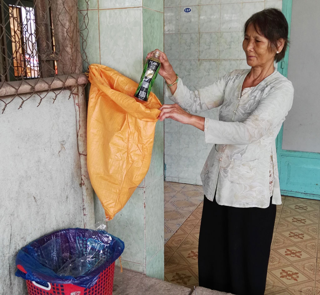 Bà Cao Thị Ngọt thực hiện phân loại rác theo hướng dẫn