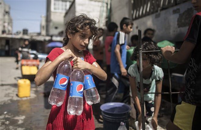 Người dân lấy nước sinh hoạt tại Dải Gaza. (Nguồn: AFP/TTXVN)