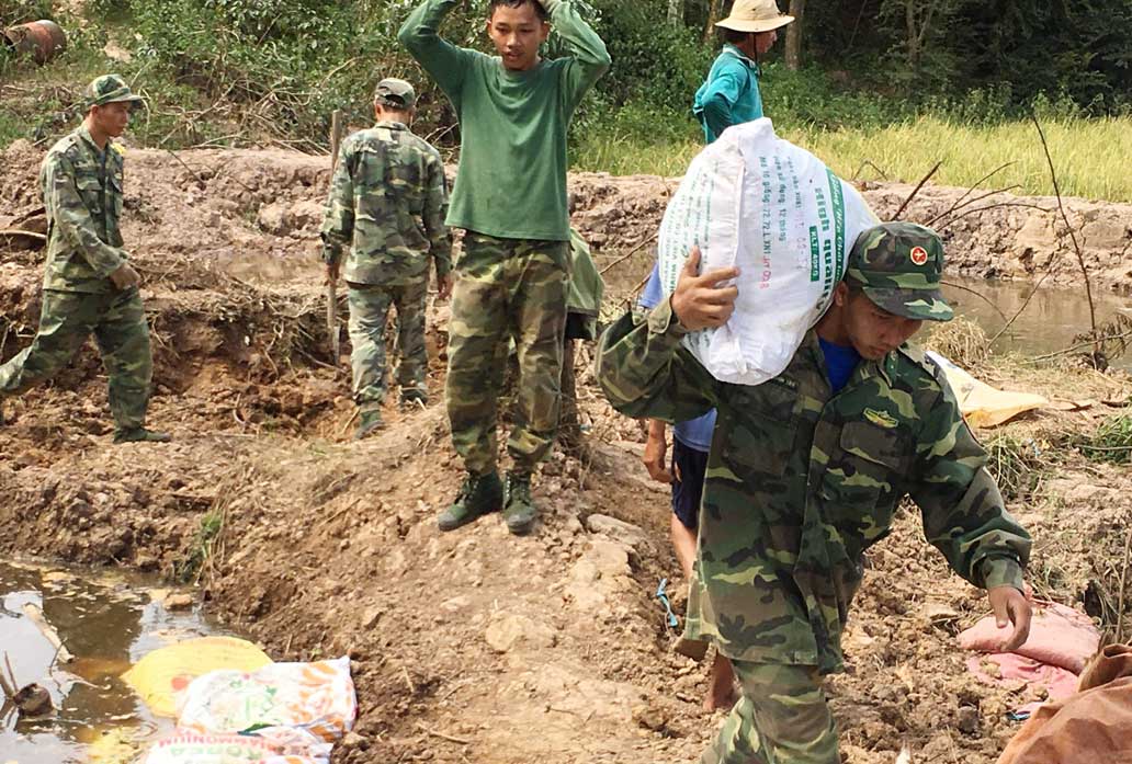 Cán bộ, chiến sĩ Đồn Biên phòng Sông Trăng giúp dân gia cố đê bao