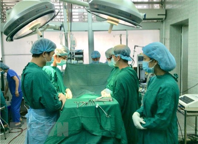 Các bác sỹ cúi đầu mặc niệm người hiến tạng. (Ảnh: TTXVN phát)