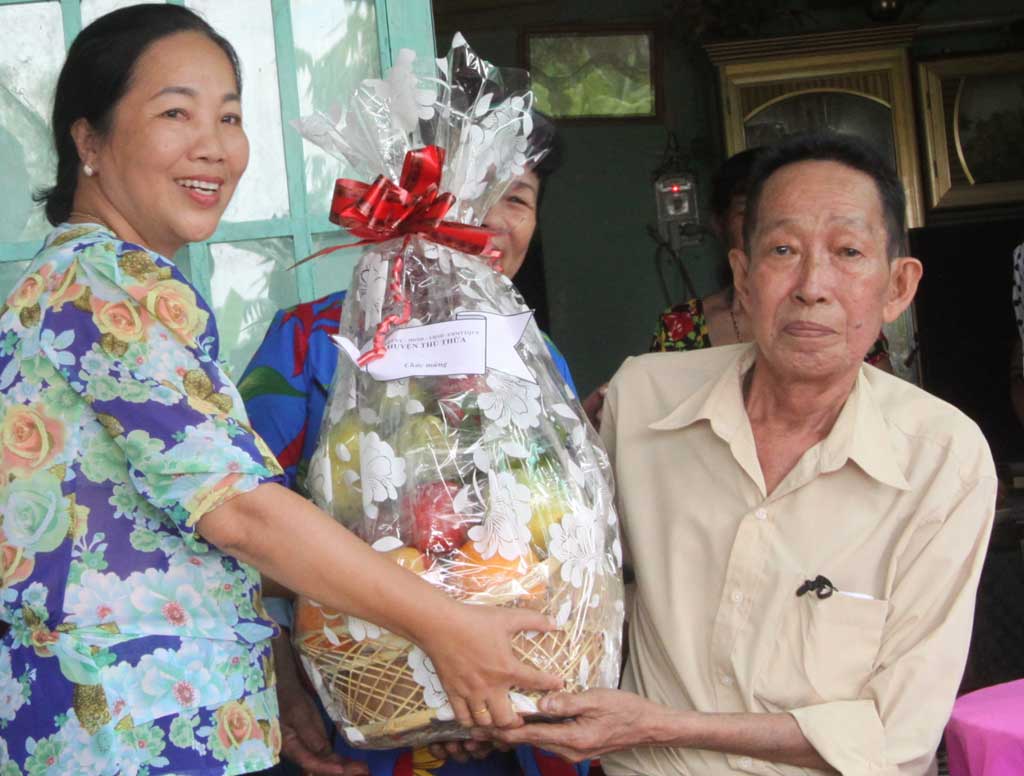 Trưởng Ban Dân vận Huyện ủy Thủ Thừa - Lê Thị Hằng tặng quà cho già đình đăng cai tổ chức tết năm 2018