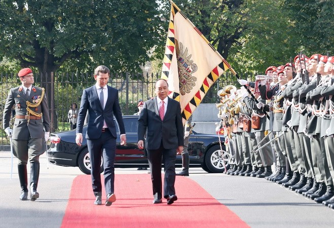Thủ tướng Áo Sebastian Kurz và Thủ tướng Nguyễn Xuân Phúc duyệt đội danh dự tại Lễ đón, được tổ chức trọng thể ở Văn phòng Thủ tướng Áo. (Ảnh: Thống Nhất/TTXVN)