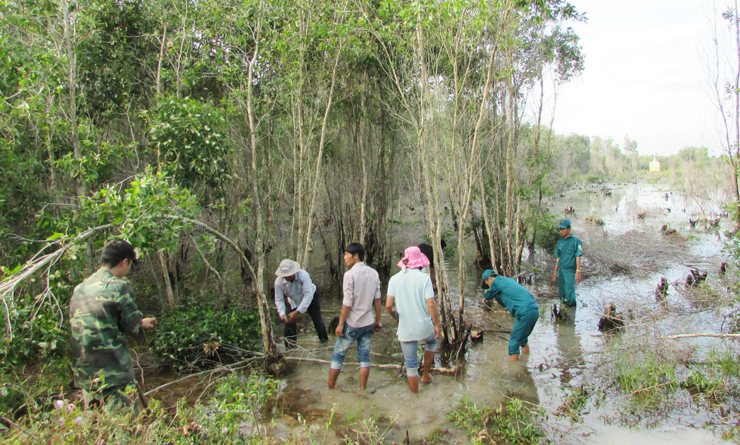 Cán bộ, chiến sĩ Đồn Biên phòng Mỹ Thạnh Tây phối hợp địa phương và người dân phát quang quanh cột mốc