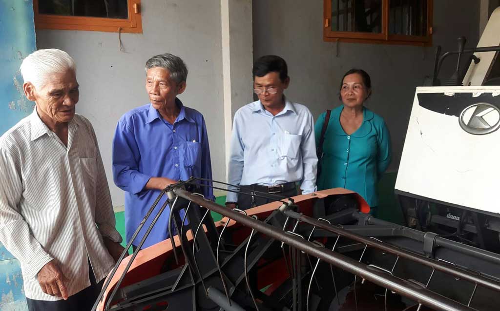 Ông Lê Văn Thử (bìa trái) đầu tư máy cày, máy gặt đập liên hợp làm dịch vụ