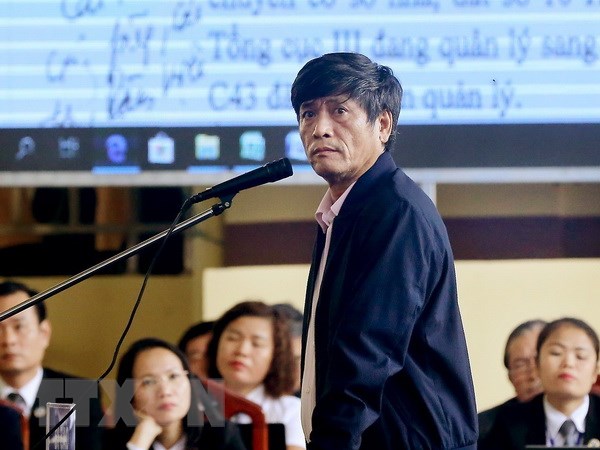 Nguyễn Thanh Hóa phủ nhận lời khai của mình tại cơ quan điều tra Bị cáo Nguyễn Thanh Hóa xem các văn bản là tang vật của vụ án được chiếu trên màn hình. (Ảnh: Trung Kiên/TTXVN)
