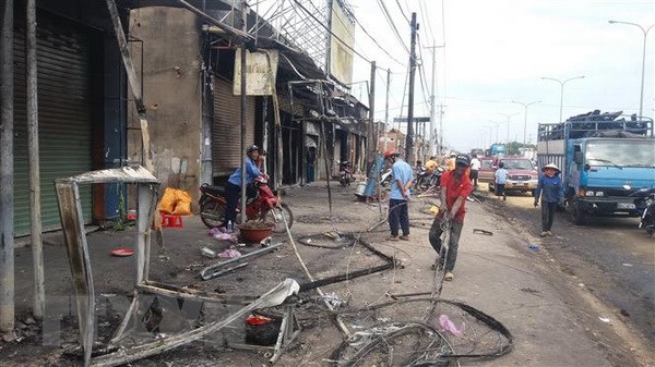 Vụ cháy xe bồn ở Bình Phước: Người dân đã trở về dọn dẹp nhà cửa Đường điện đang được lực lượng chức năng cho khắc phục. (Ảnh: Đậu Tất Thành/TTXVN)