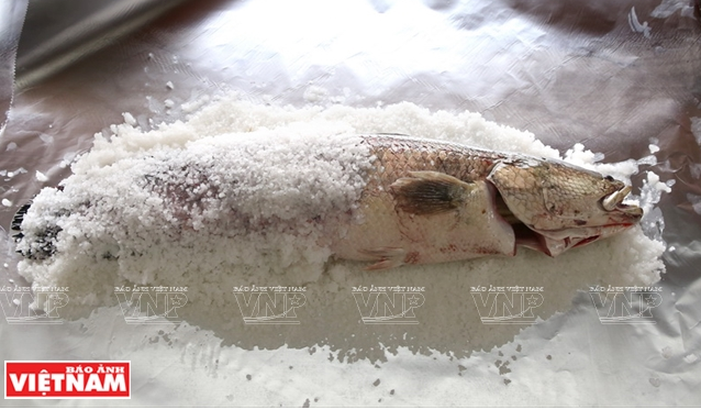 Cá sau khi sơ chế được bọc bằng muối hạt và gói trong giấy bạc.