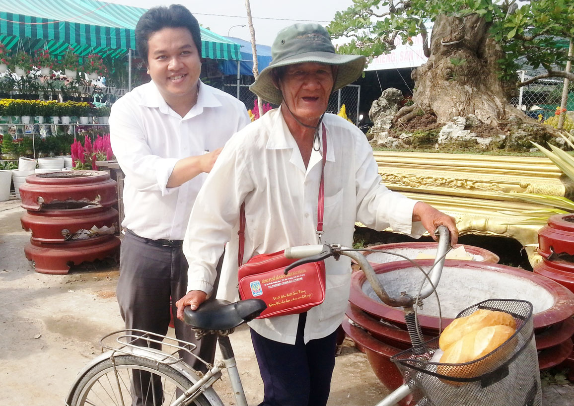 Anh Phạm Hoài Phong hỗ trợ cụ già nhận bánh mì từ thiện
