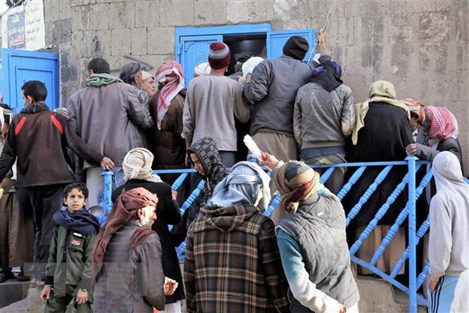 Người dân xếp hàng đợi nhận khẩu phần ăn tại một trung tâm cứu trợ ở thủ đô Sanaa, Yemen. (Ảnh: THX/TTXVN)