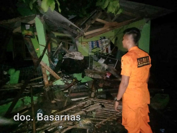 Một nhân viên cứu hộ đang kiểm tra một khu vực bị tàn phá trong sóng thần ở tỉnh Baten - Ảnh: Reuters