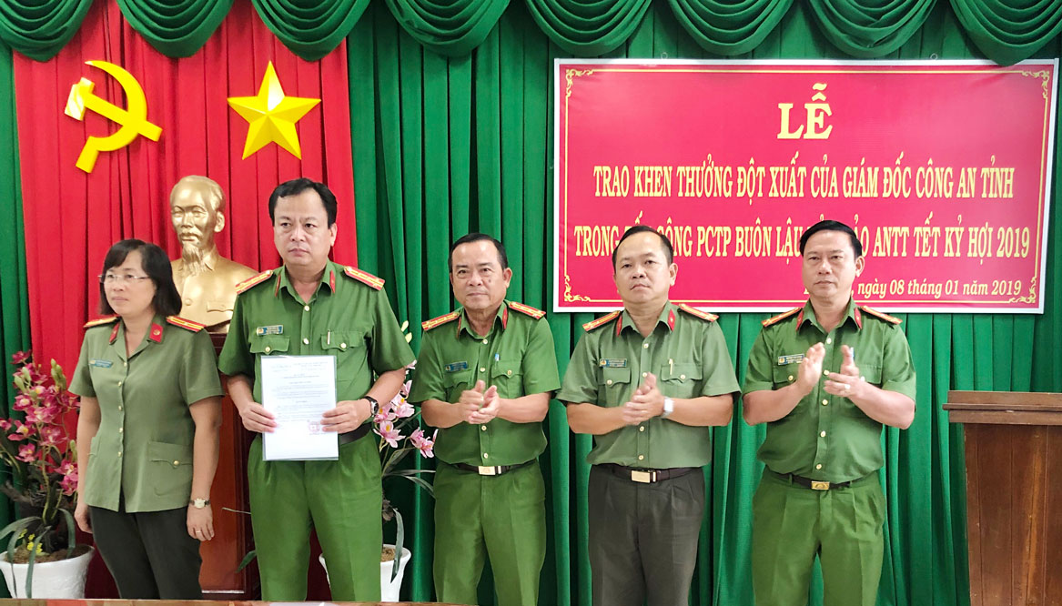 Đại tá Phạm Hữu Châu (giữa) - Phó Giám đốc Công an tỉnh, trao thưởng nóng cho Công an huyện Bến Lức 10 triệu đồng về thành tích xuất sắc trong công tác chống buôn lậu