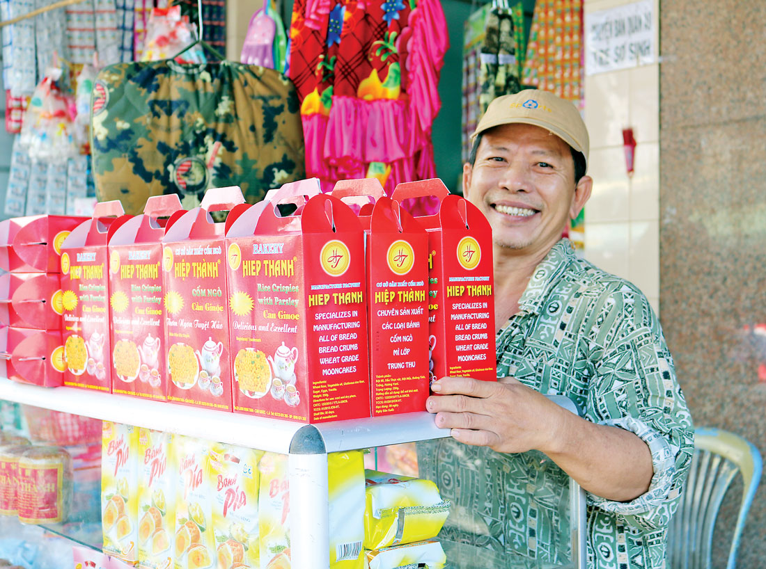 Ông Lý Đông Khê - chủ Cơ sở sản xuất cốm ngò Hiệp Thành, bên sản phẩm của mình