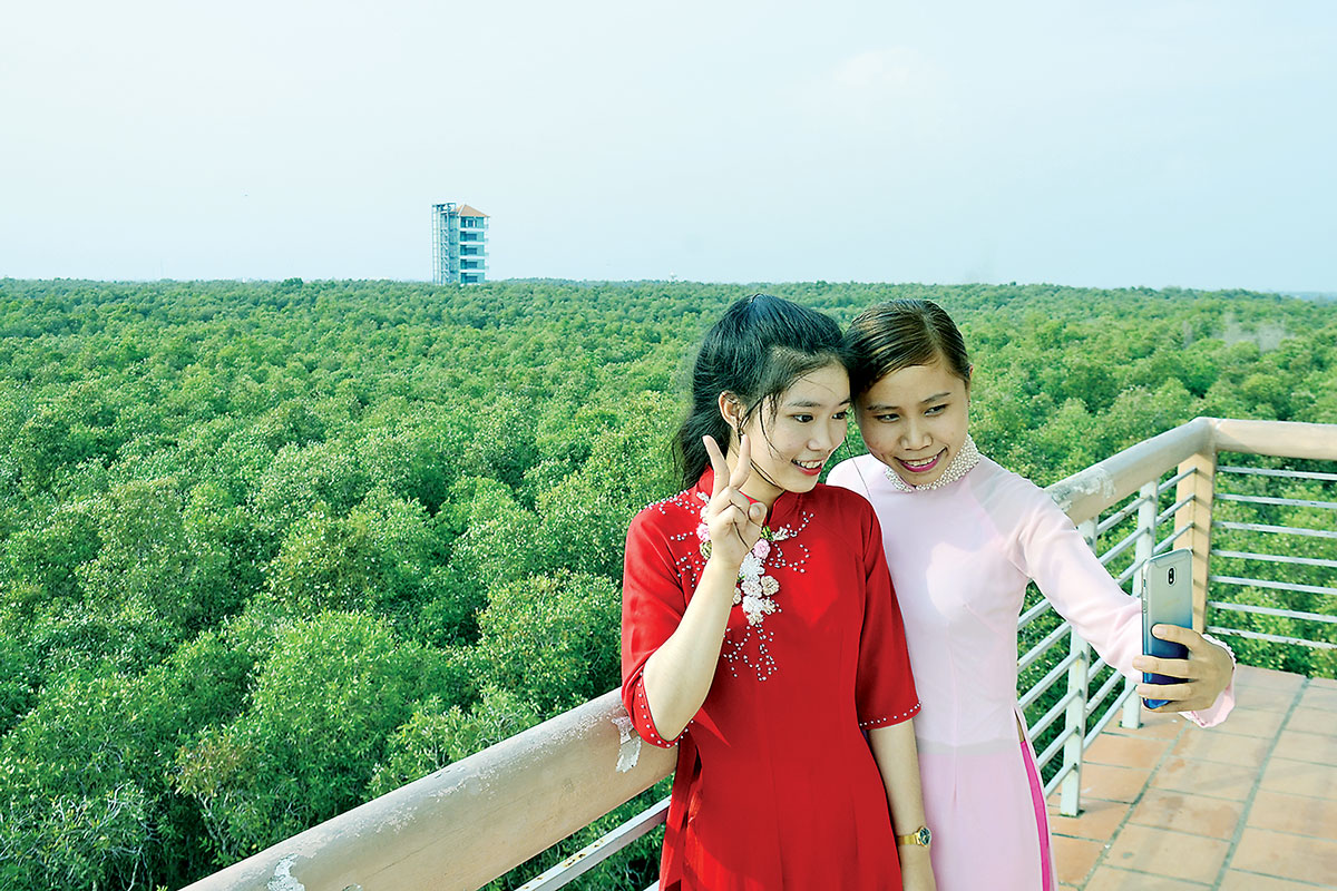 Du khách chụp ảnh trên tháp cao tại Làng nổi Tân Lập  (Ảnh do khu du lịch cung cấp)