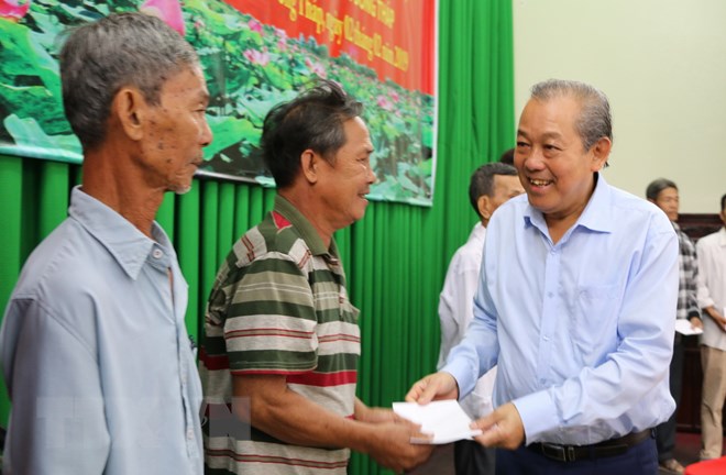 Phó Thủ tướng Trương Hòa Bình tặng quà cho các gia đình hộ nghèo hai huyện Tháp Mười và Cao Lãnh, tỉnh Đồng Tháp. (Ảnh: Chương Đài/TTXVN)