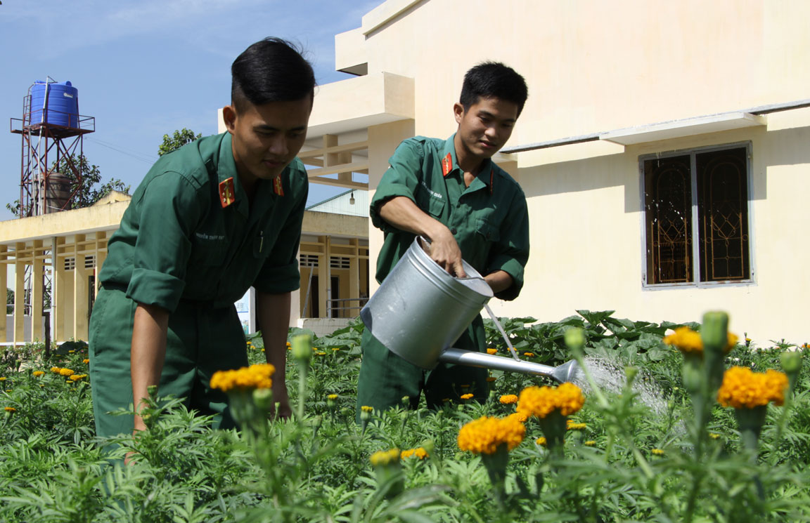 Thượng sĩ Nguyễn Thành Đạt và Trung sĩ Trần Minh Quân tranh thủ giờ nghỉ chăm lại mấy luống hoa chào tết trong tiểu đoàn như món quà gửi lại cho các chiến sĩ trẻ đón tết tại đơn vị