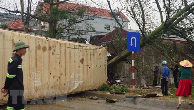 Xe container bị lật nghiêng, nằm chắn ngang làn đường ngược chiều khiến các phương tiện giao thông không thể đi qua làn đường này. (Ảnh: Khiếu Tư/TTXVN)