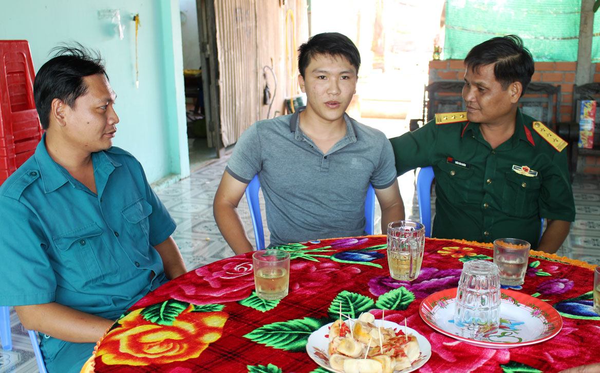 Thượng tá Trần Văn Khiêm - Chính trị viên Ban Chỉ huy Quân sự huyện Bến Lức (bìa phải), cùng đại diện Ban Chỉ huy Quân sự xã Long Hiệp đến thăm Lê Phước Thành trước khi lên đường nhập ngũ
