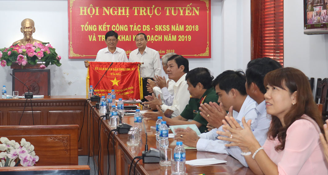 Bác sĩ Võ Văn Thắng trao cờ thi đua của UBND tỉnh cho đơn vị huyện Cần Đước