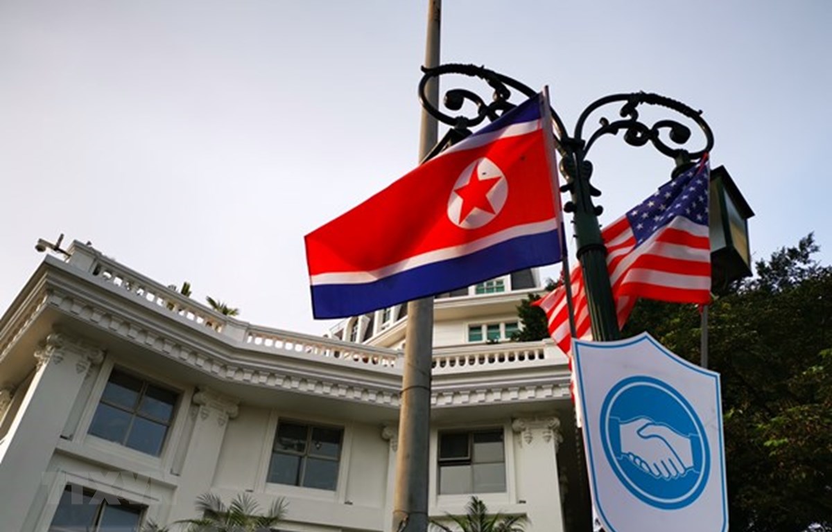 Cờ Mỹ và cờ Triều Tiên, bên dưới là biểu tượng hai bàn tay bắt chặt vào nhau thể hiện tinh thần của cuộc gặp lớn, được treo bên ngoài khu vực Quảng trường 19/8 - Nhà hát Lớn - Khách sạn Hilton Opera, Quận Hoàn Kiếm. (Ảnh: Thành Đạt/TTXVN)