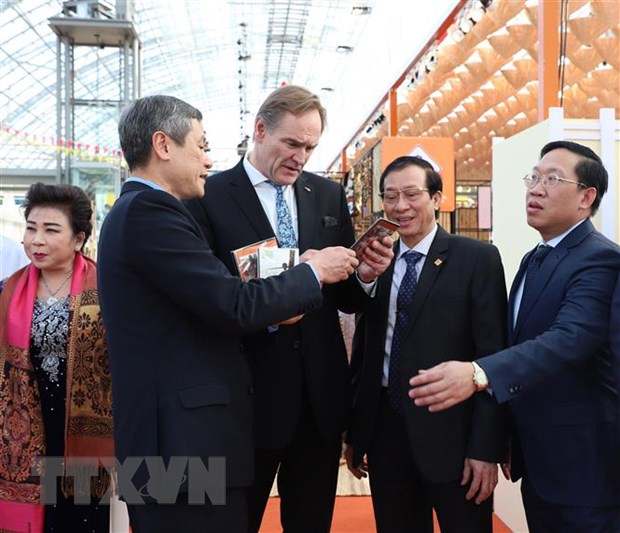 Đại sứ Nguyễn Minh Vũ tặng ông Burghard Jung, Thị trưởng thành phố Leipzig, ấn phẩm về thành tự kinh tế-xã hội của Việt Nam sau 30 năm đổi mới. (Ảnh: Thanh Bình/TTXVN)