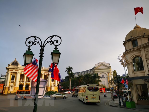 Cờ Mỹ và cờ Triều Tiên, bên dưới là biểu tượng hai bàn tay bắt chặt vào nhau thể hiện tinh thần của cuộc gặp lớn, được treo trên tuyến phố Tràng Tiền, trước khu vực Quảng trường 19/8 - Nhà hát Lớn - Khách sạn Hilton Opera, Quận Hoàn Kiếm. (Ảnh: Thành Đạt/