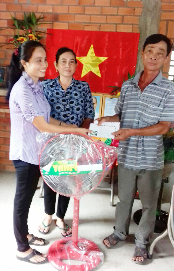 Chị Nguyễn Thị Xiệt (bìa trái) tặng quà người dân có hoàn cảnh khó khăn
