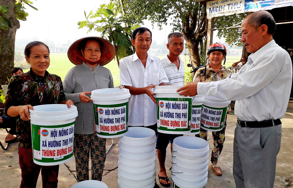 Nông dân xã Hướng Thọ Phú phát thùng rác cho nông dân góp phần bảo vệ môi trường nông thôn