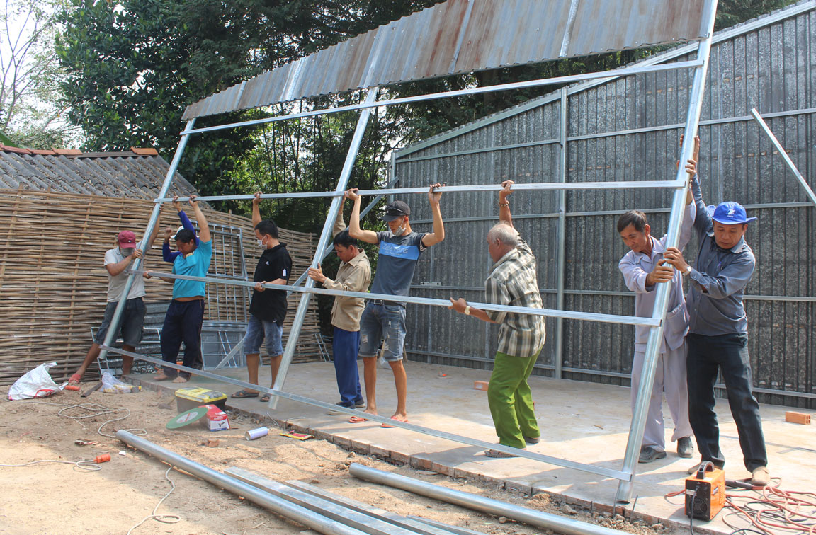 Những người trong Tổ Từ thiện Thành Tâm và hàng xóm, láng giềng đến dựng nhà cho bà Nguyễn Thị Hứng