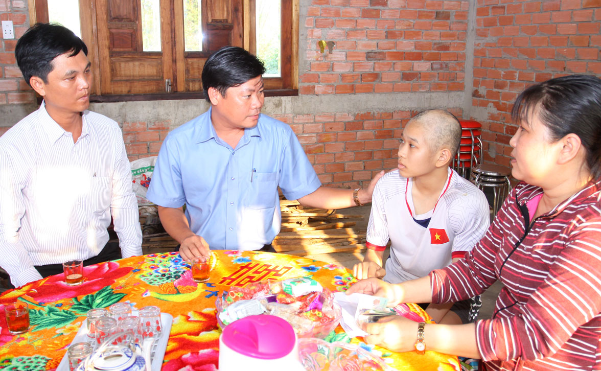 Chủ tịch UBND huyện Cần Đước - Huỳnh Văn Quang Hùng (thứ hai, trái qua) trao tặng 20 triệu đồng cho gia đình em Văn Thị Lâm Thi