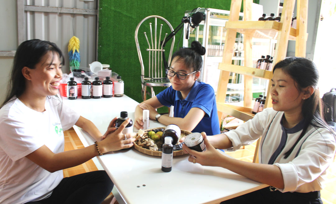 Chị Huỳnh Thị Kim Hoàng (bìa phải) đang tư vấn cho khách hàng về công dụng của dầu gội không bọt Yopoo