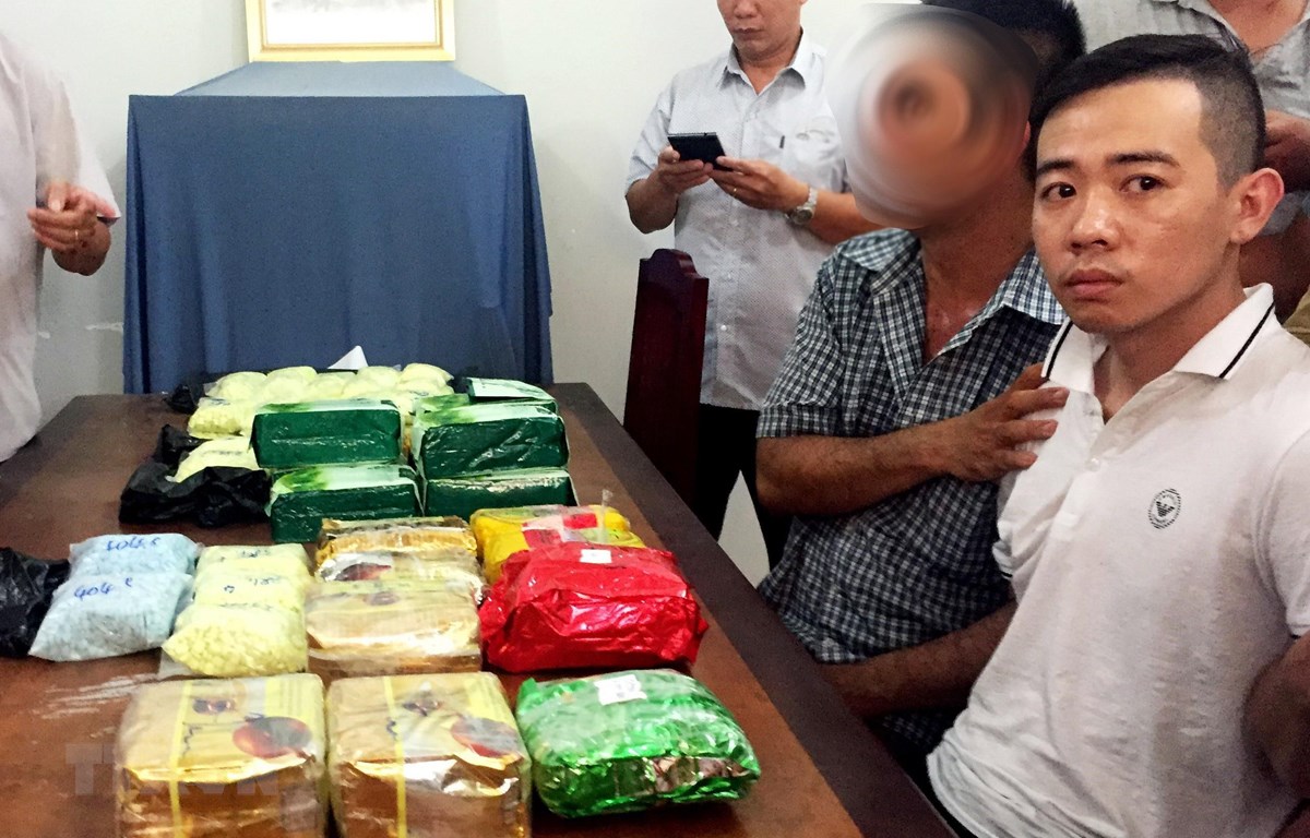 Du Quốc Cường (áo trắng bìa phải, sinh năm: 1990, đăng ký thường trú: 117 Hồng Bàng, Tân Lập, thành phố Nha Trang, tỉnh Khánh Hòa) bị bắt quả tang cùng nhiều ma túy. (Ảnh: Công Mạo/TTXVN)