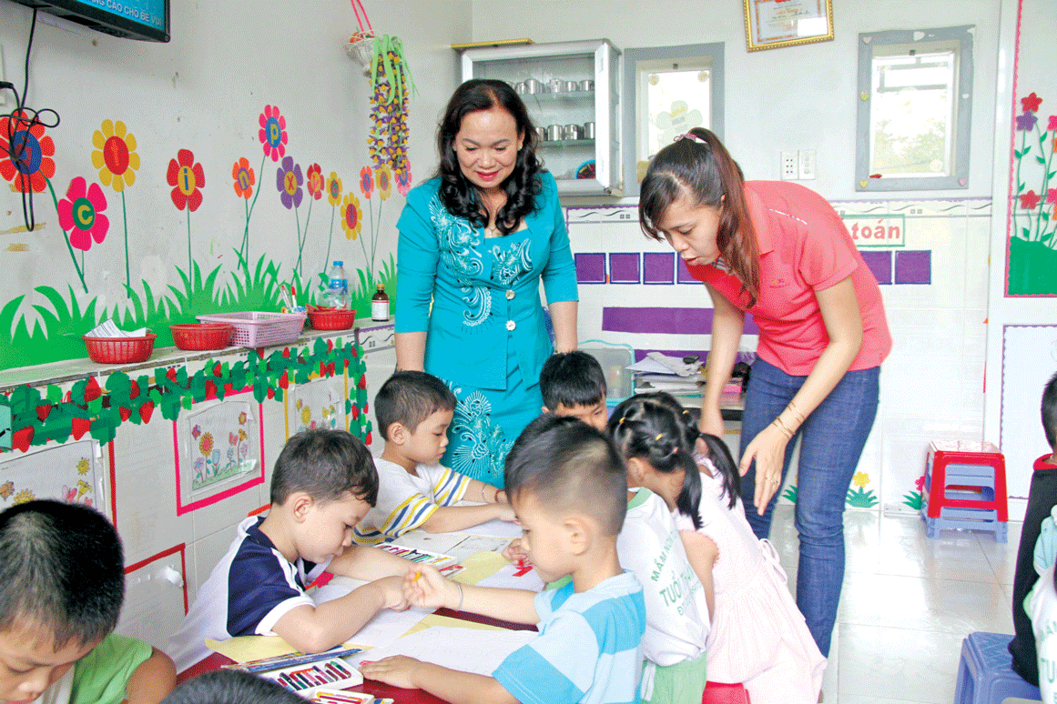 Chị Hồ Thị Kim Loan (áo xanh) không chỉ tham gia tốt công tác xã hội  tại địa phương mà còn mở 1 lớp giữ trẻ miễn phí dành riêng cho trẻ em nghèo