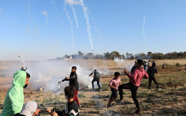 Binh sỹ Israel bắn đạn hơi cay về phía người biểu tình Palestine trong cuộc đụng độ tại khu vực biên giới Israel và Dải Gaza ngày 19/4. (Ảnh: THX/TTXVN)