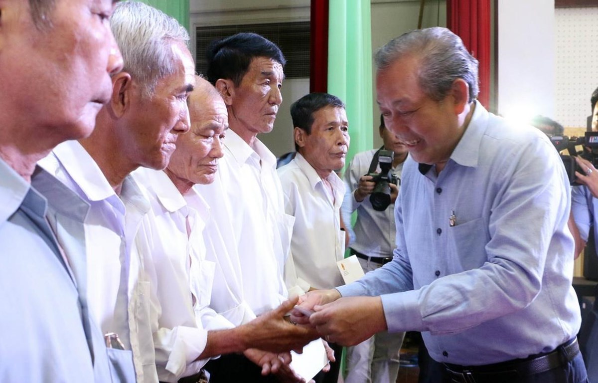 Phó Thủ tướng Thường trực Trương Hòa Bình trao quà cho các gia đình chính sách. (Ảnh: Trần Thị Thu Hiền/TTXVN)