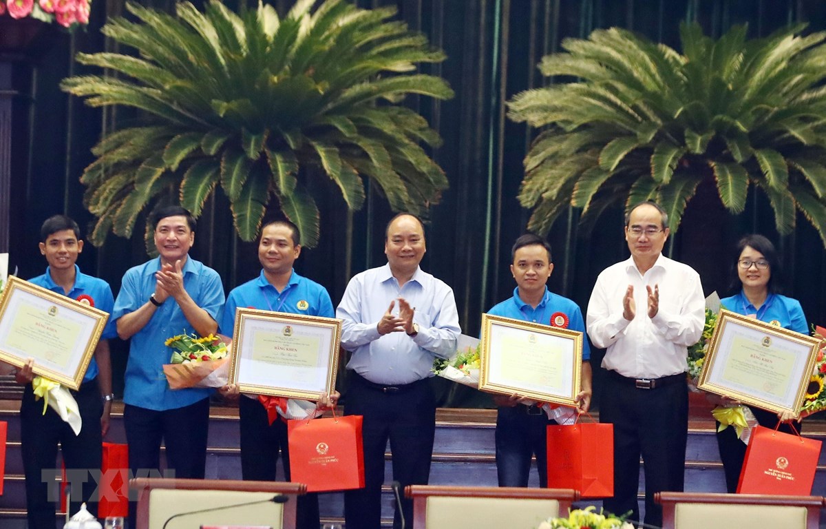 Thủ tướng Nguyễn Xuân Phúc tặng quà cho công nhân, lao động kỹ thuật cao. (Ảnh: Thống Nhất/TTXVN)