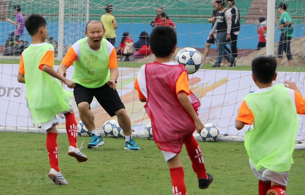 Huấn luyện viên Park Hang Seo vui vẻ chơi bóng cùng các em học sinh. (Ảnh: Trung Kiên/TTXVN)
