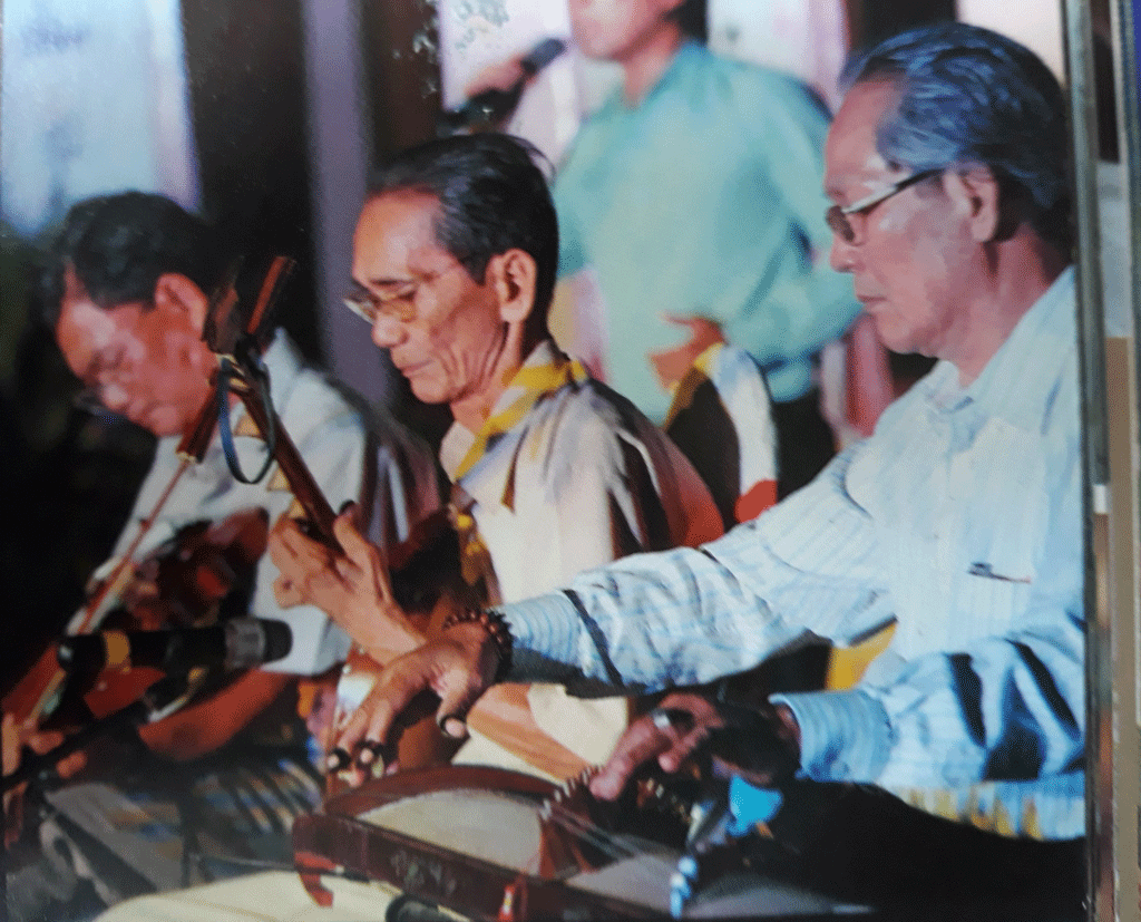Nghệ nhân nhân dân Bảy Vân (giữa) hòa đờn cùng Nhà nghiên cứu văn hóa, văn nghệ dân gian Võ Trường Kỳ (bên phải)