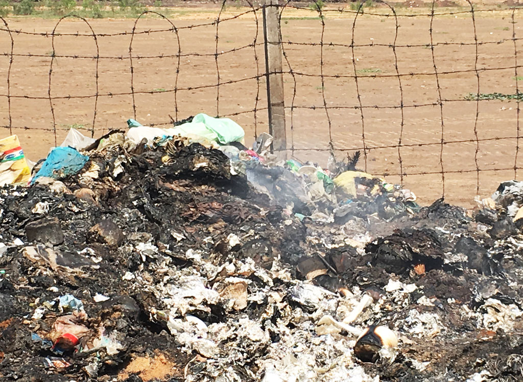 Waste is disposed without regulations and burnt at the fence of the Hanh Phuc IP along Kenh Tay road