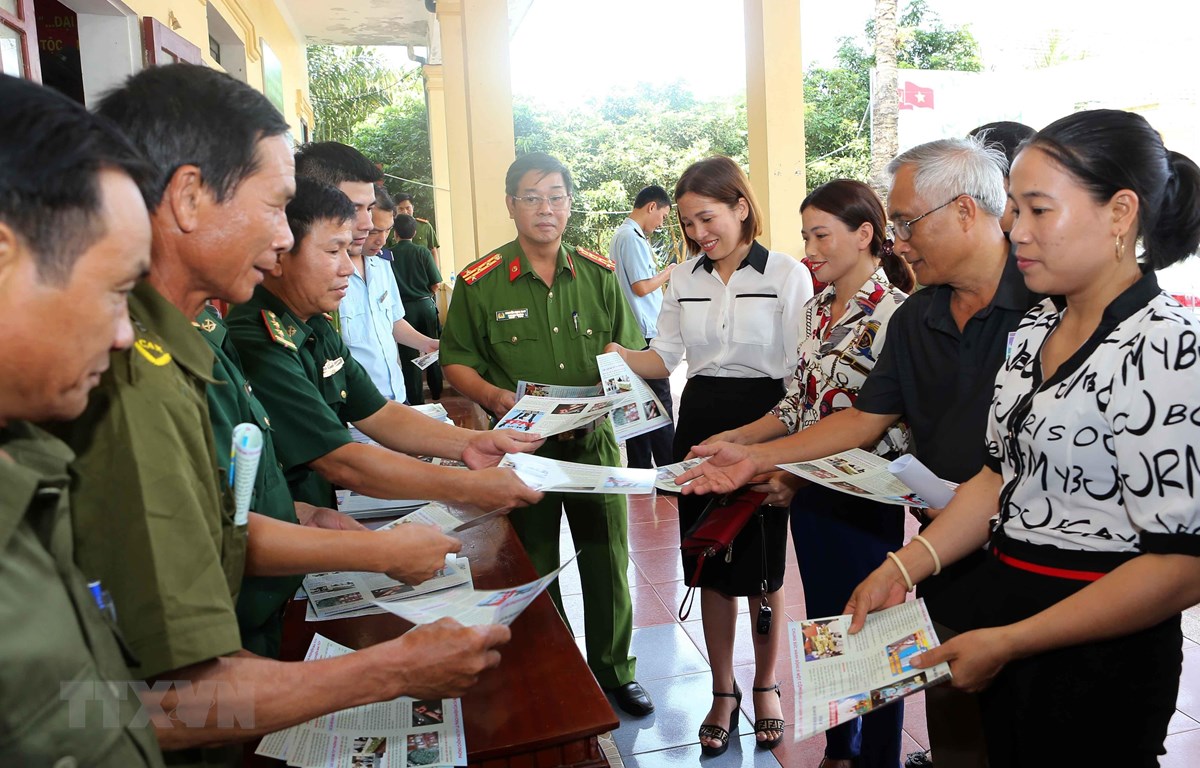 Lực lượng biên phòng, công an và tuyên truyền viên phát tờ rơi tuyên truyền về phòng, chống ma túy đến nhân dân địa bàn xã Sơn Kim 1, huyện Hương Sơn, tỉnh Hà Tĩnh. (Ảnh: Doãn Tấn/TTXVN)