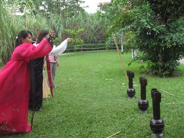Various activities in Hanoi celebrate children’s festival Participants try to throw sticks into jars, a traditional Korean game. The game will be featured in the Children's Festival on June 1-2 at the Museum of Ethnology. (Source: VNA)