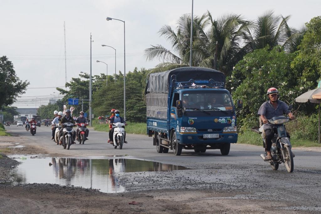 Xe mô tô tránh hố sâu lưu thông ra giữa đường.