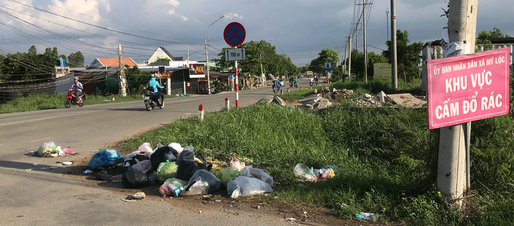 Mặc dù chính quyền địa phương đã cắm bảng cấm đổ rác nhưng một số người vẫn bỏ rác tràn lan ven đường (Ảnh chụp ngày 11/6/2019)