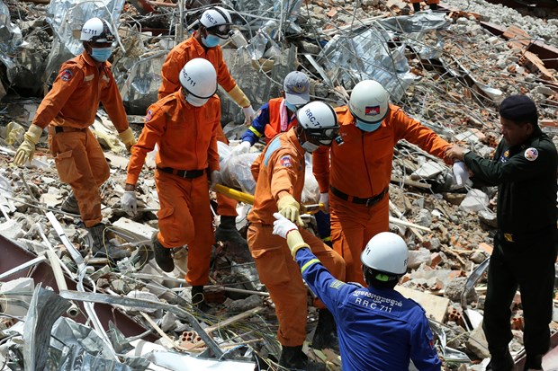Nhân viên cứu hộ tìm kiếm nạn nhân trong vụ sập nhà cao tầng ở tỉnh Preah Sihanouk, miền Nam Campuchia, ngày 23/6. (Nguồn: AFP/TTXVN)