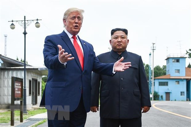 Tổng thống Mỹ Donald Trump (trái) và nhà lãnh đạo Triều Tiên Kim Jong-un trong cuộc gặp ở làng đình chiến Panmunjom tại Khu phi quân sự (DMZ) chiều 30/6/2019. (Ảnh: AFP/TTXVN)