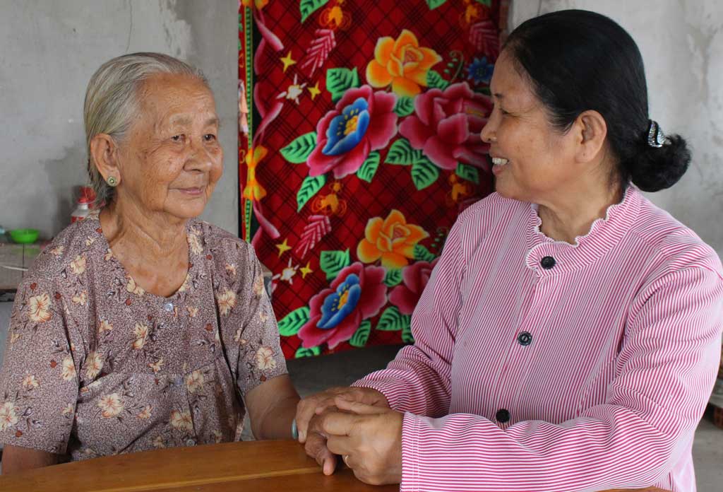 Bà Lê Thị Quít (bìa trái) an tâm khi được sống trong ngôi nhà mới kiên cố