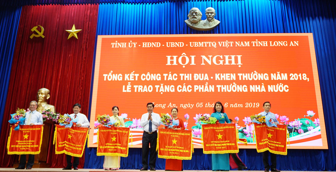 Đại diện lãnh đạo Hội Liên hiệp Phụ nữ Việt Nam tỉnh - Phó Chủ tịch Nguyễn Thụy Thắm (thứ 3, từ phải qua) nhận cờ thi đua của Chính phủ