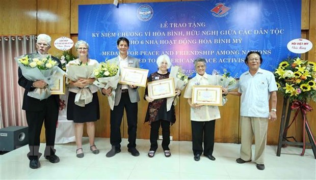 Chủ tịch Hội Việt-Mỹ Nguyễn Tâm Chiến trao tặng Kỷ niệm chương Vì hòa bình, hữu nghị giữa các dân tộc cho các nhà hoạt động hòa bình Mỹ. (Ảnh: TTXVN phát)