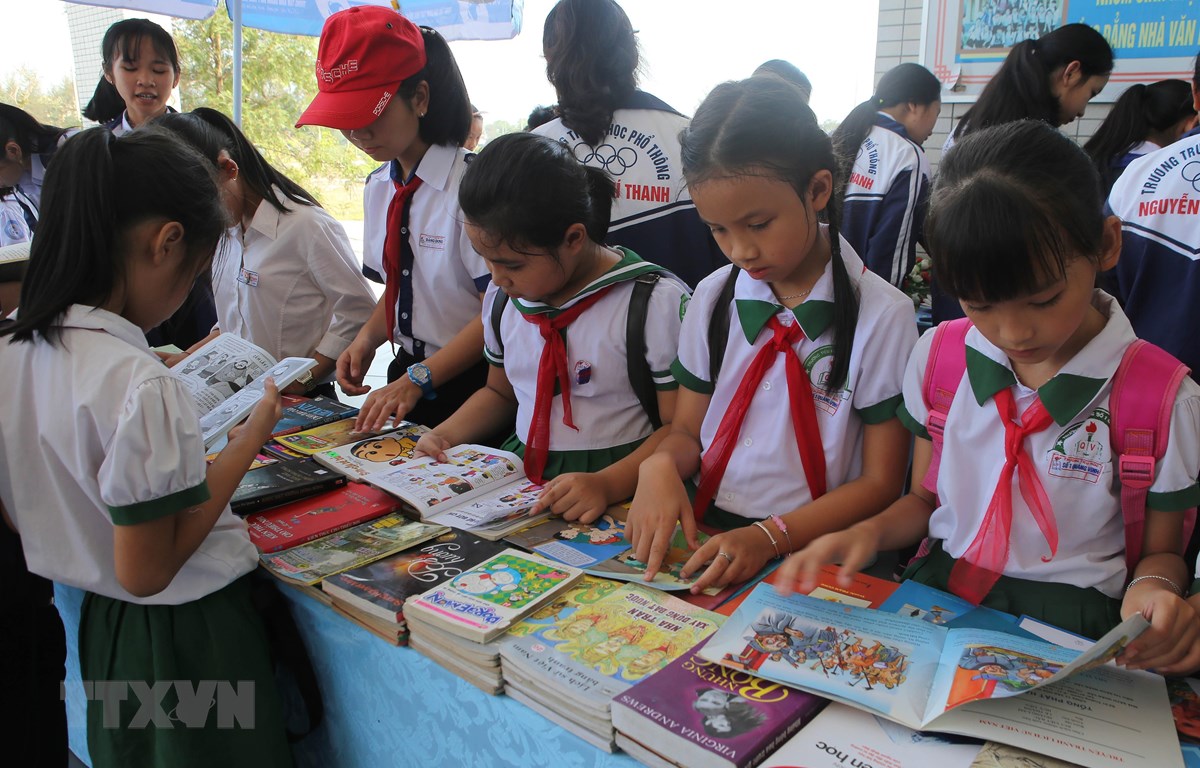 Học sinh huyện Quảng Điền tham quan triển lãm và đọc sách trong Ngày sách Việt Nam. (Ảnh: Hồ Cầu/TTXVN)