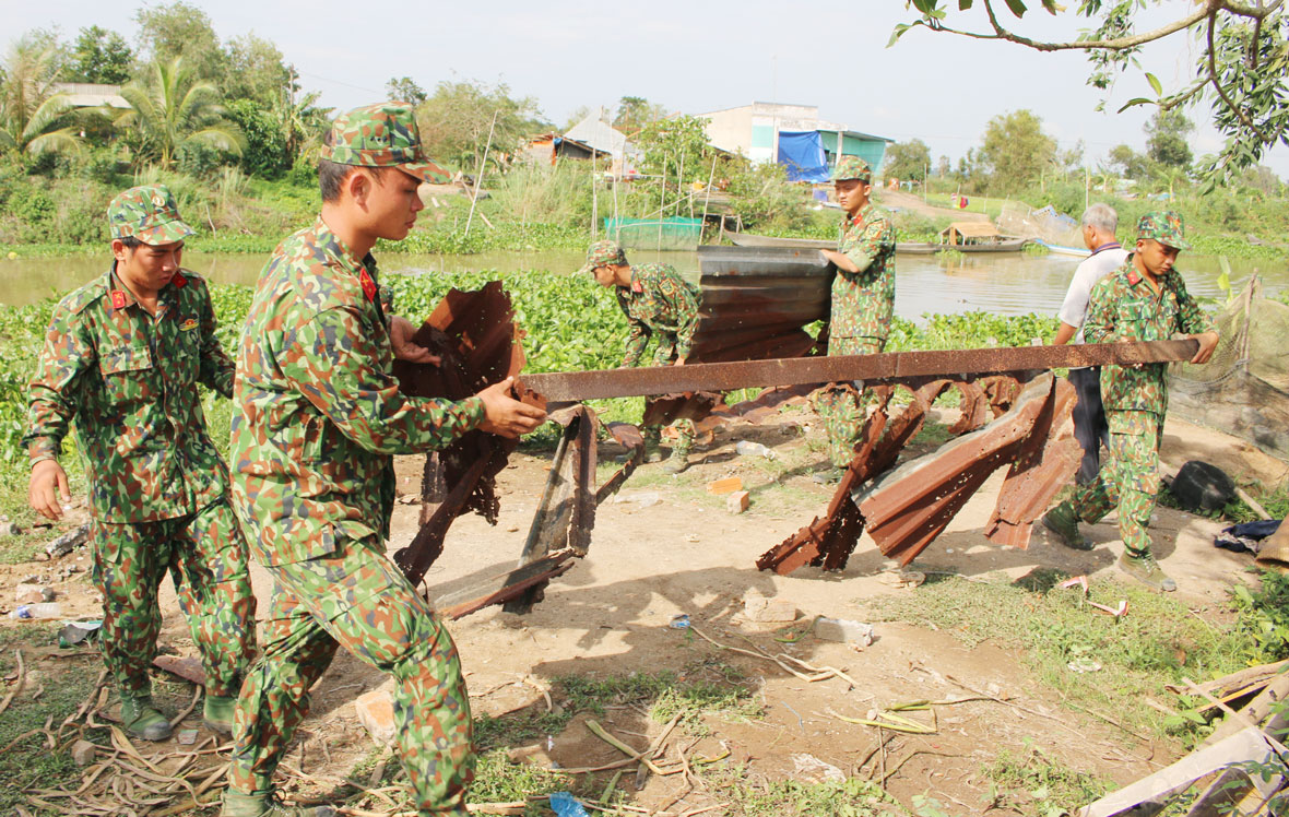 Cán bộ, chiến sĩ Đại đội Bộ binh huyện Tân Hưng giúp dân khắc phục hậu quả mưa giông